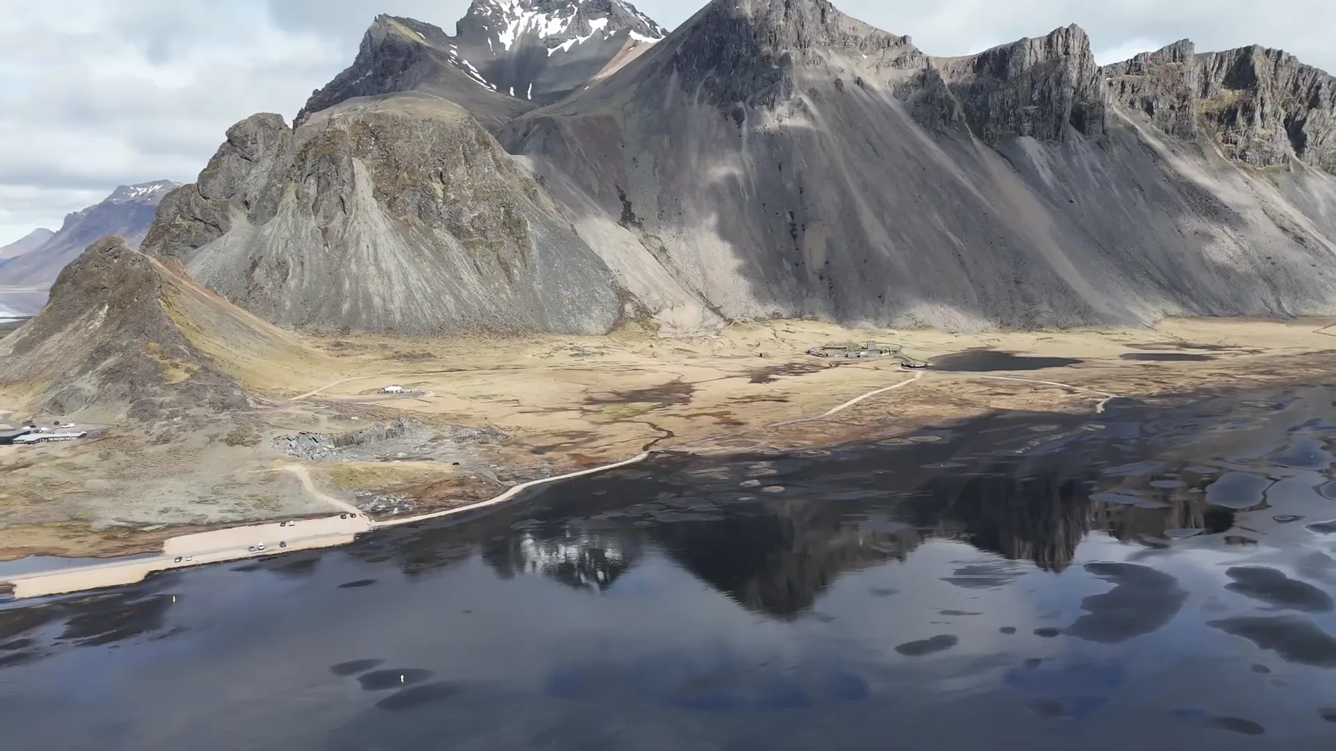 Iceland — Vestrahorn mountains reflected at Stokksnes, drone shot by Ludusware